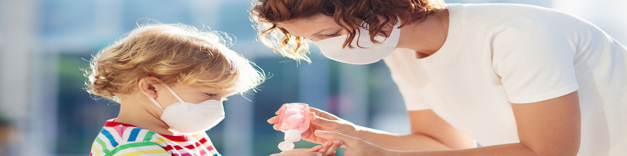 adult and child interacting with masks covering their faces 
