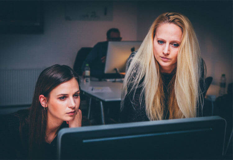 two women looking at computer screen